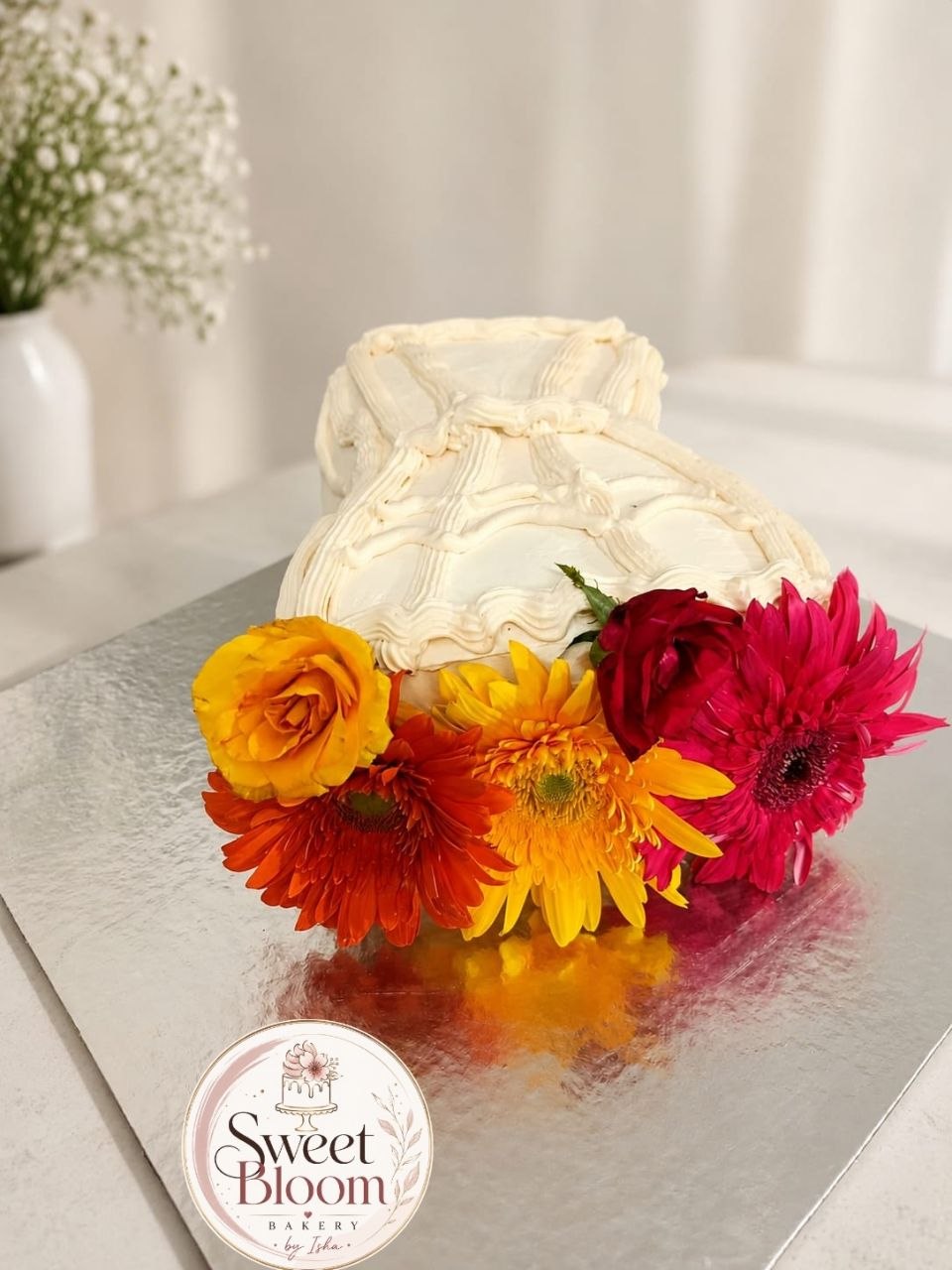 Ivory buttercream basket cake with vibrant gerbera daisies and roses — Sweet Bloom Bakery, Asansol